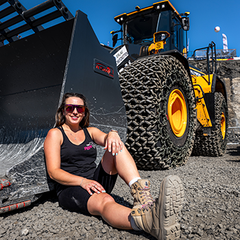 Amy Underwood sitting next to a front loader shovel