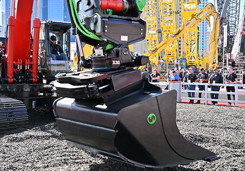 Demonstration of a bucket on an excavator as people look on