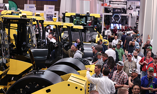 CONEXPO-CON/AGG floor featuring multiple large yellow road rollers on display, surrounded by attendees exploring construction equipment