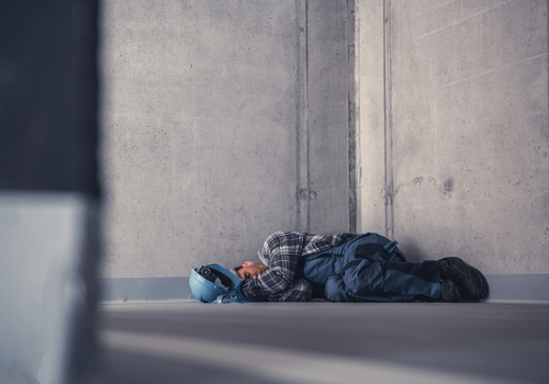 Exhausted Construction Worker Sleeping on a Raw Concrete at Work While on His Shift. Physical and Mental Issues Theme.