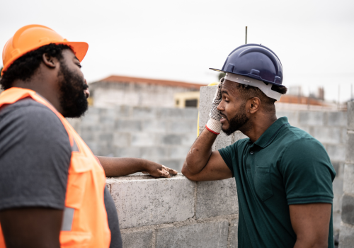 Worried coworkers talking in a construction site